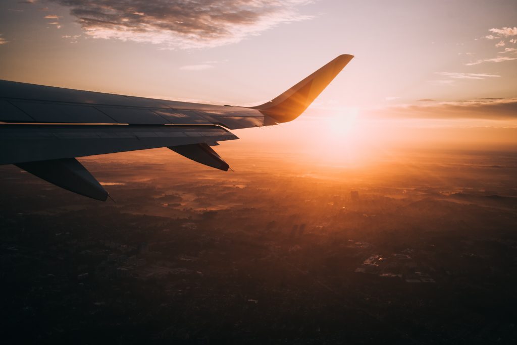 Fensterblick aus dem Flugzeug mit Blick auf untergehende Sonne